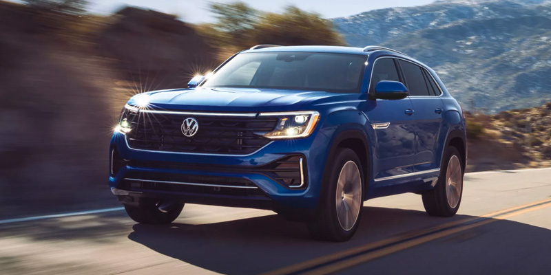 Blue Volkswagen Atlas driving on a scenic road