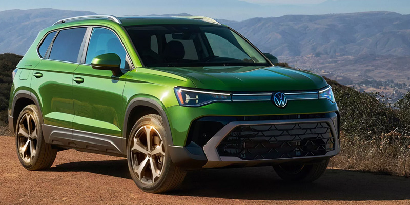 A green Volkswagen Taos in a rugged landscape.