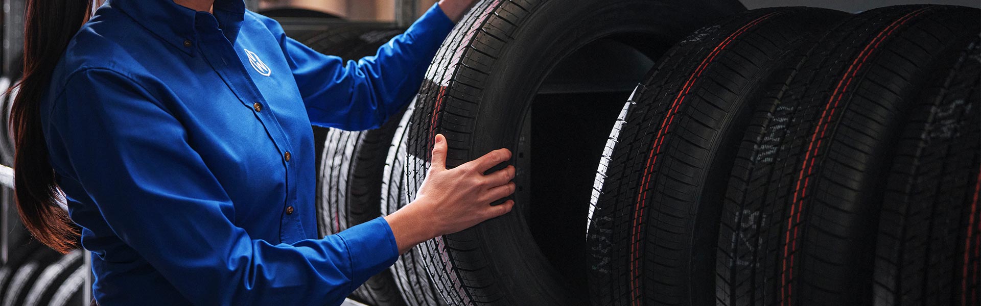 Technician handling stacked tires indoors